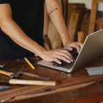 man checking information on laptop on timber table