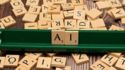 a green scrabble board with letters spelling out ai